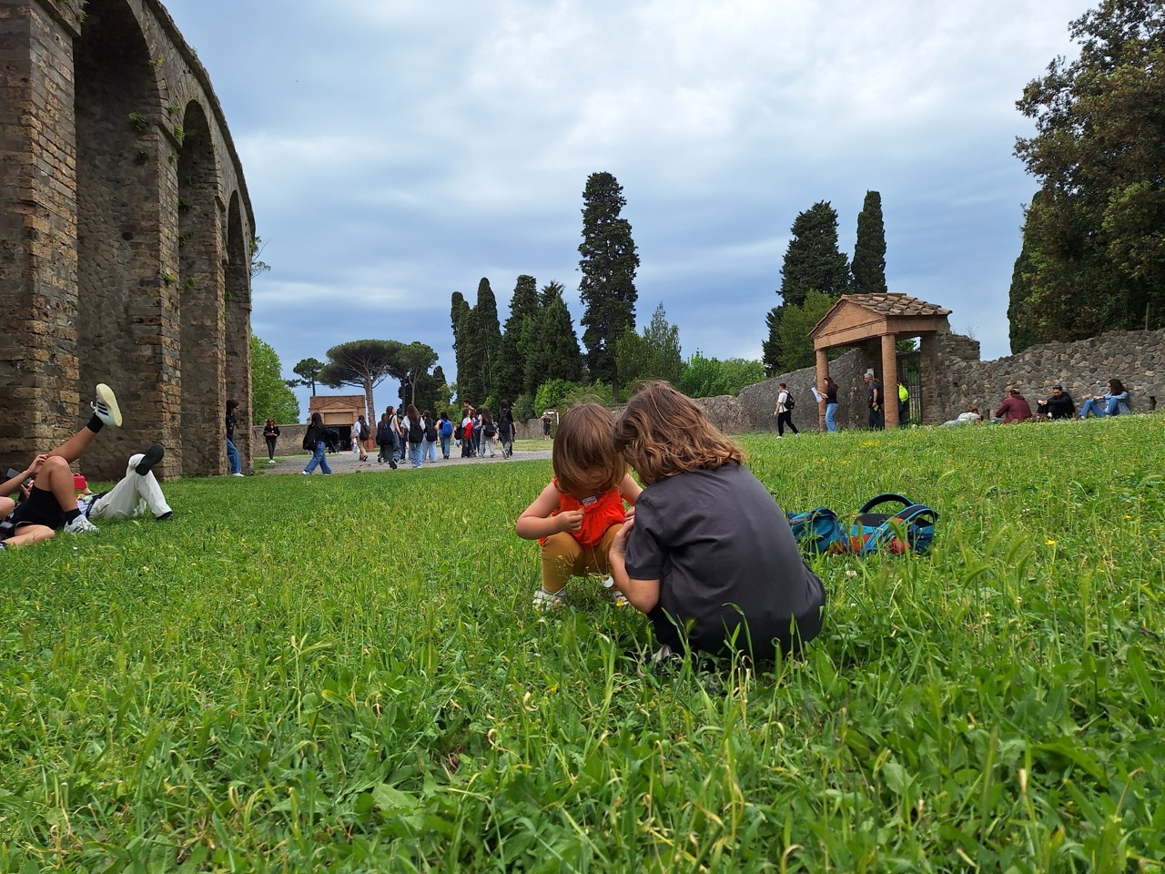 Kids sitting on the grass at Pompeii
