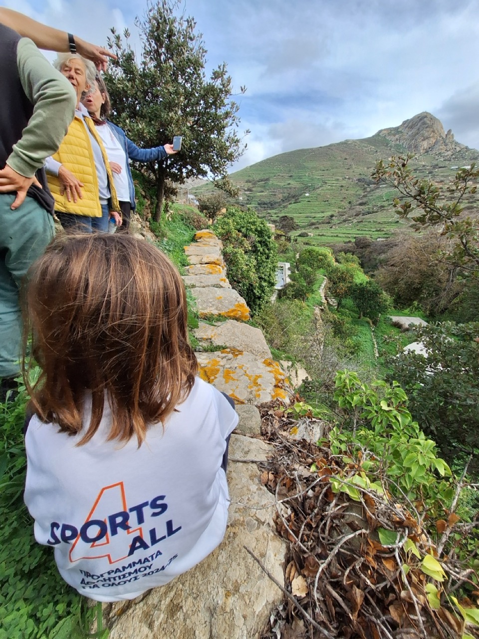 A guide showing the way on a stone path in Tinos