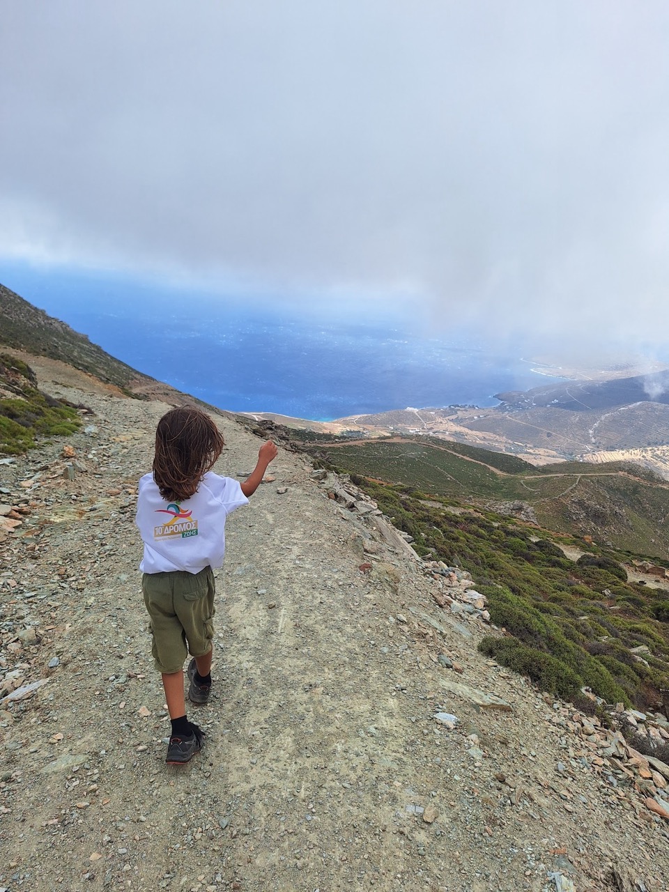 A child scrambling up a bare granite slope on Tsiknias